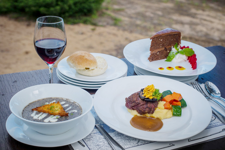 A lovingly crafted gourmet meal consisting of soup, steak, potatoes, steamed vegetables and cake for dessert, a part of a guest's experience at Tazin Lake Lodge, Saskatchewan